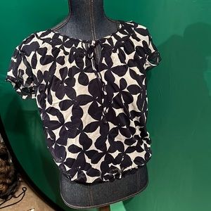 Short sleeve blouse with a floral pattern and a few sequins.